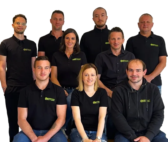 Gruppenfoto des PIT IT Teams: zehn Personen in Firmenpolos, lächelnd, vor hellem Hintergrund.